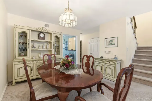 a view of a dining room with furniture a chandelier and wooden floor