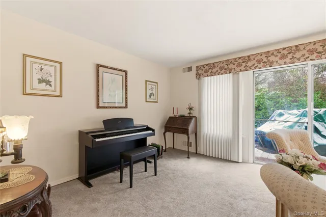 a view of a workspace with furniture and a window