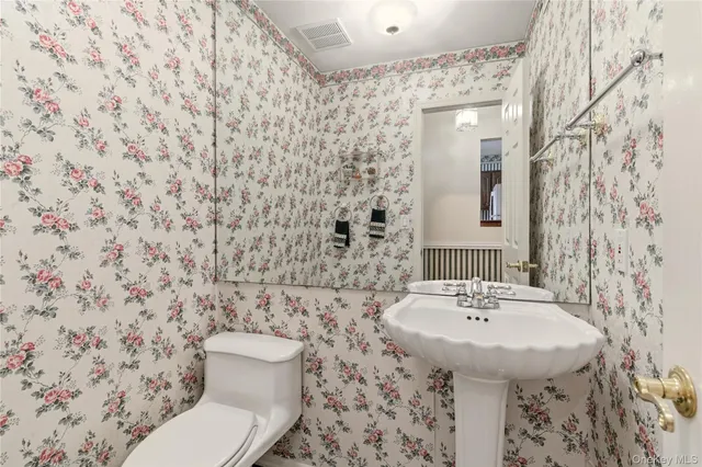 a bathroom with a sink a toilet and mirror