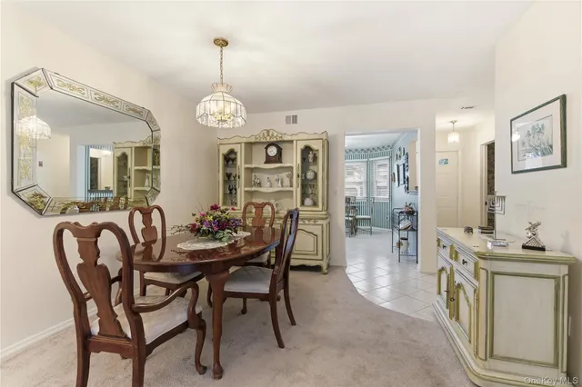 a dining room with furniture a chandelier and wooden floor