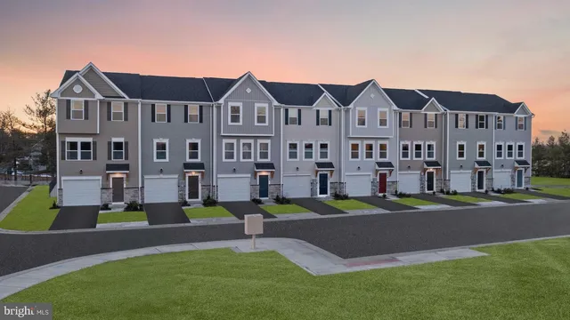 a front view of a building with garden and trees