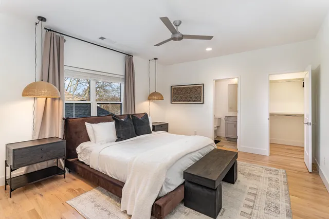 a bedroom with a large bed and a chandelier