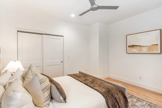 a bedroom with a bed and a painting on the wall