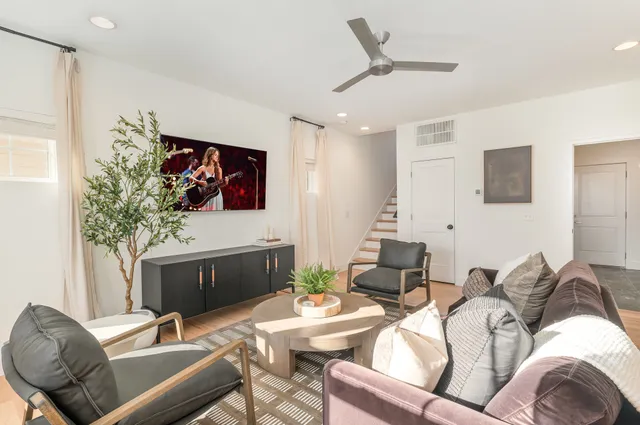 a living room with furniture a ceiling fan and a window