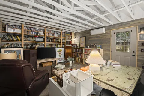 a view of a patio with table and chairs potted plants and floor to ceiling window