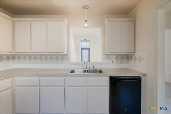 a kitchen with a sink cabinets and window