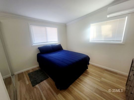 1512 South Mahan Street Ridgecrest, CA 93555 - Photo 9 of 16 a bedroom with a bed wooden floor and window
