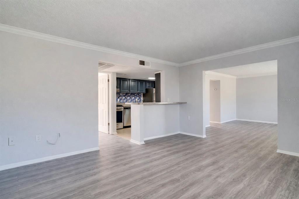 129 Blue Pointe Way, Unit 340 Altamonte Springs, FL 32701 - Photo 5 of 25 a view of a kitchen and an empty room with wooden floor and a kitchen