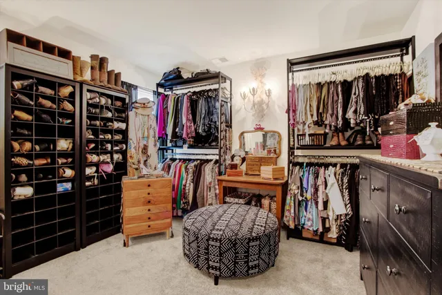 a view of walk in closet with clothes and shoes