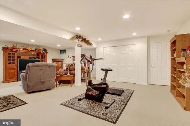a living room with furniture and a gym machine