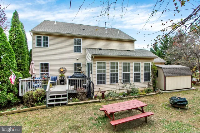 a view of a garage with a bench and a tree