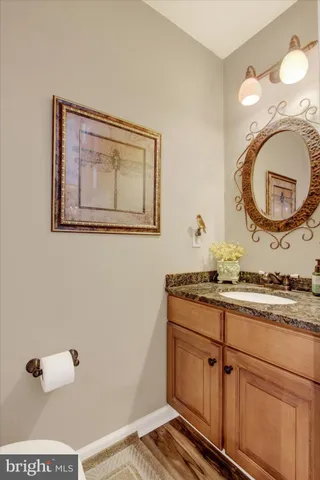 a bathroom with a granite countertop toilet a mirror and a sink