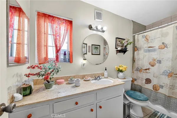 a bathroom with a sink mirror vanity and toilet