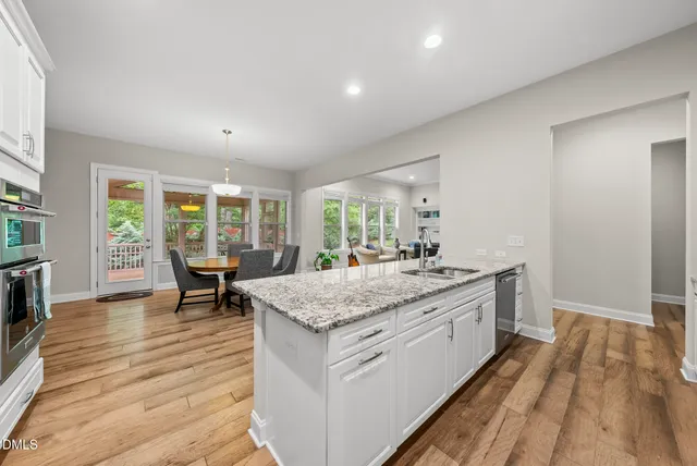 a kitchen with granite countertop white cabinets and a stove