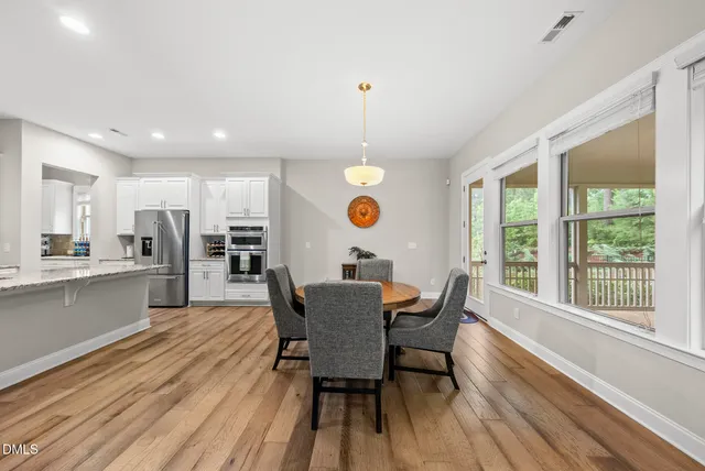 a utility room with stainless steel appliances lots of clutter and refrigerator