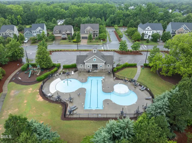 an aerial view of a house with a yard and trees all around