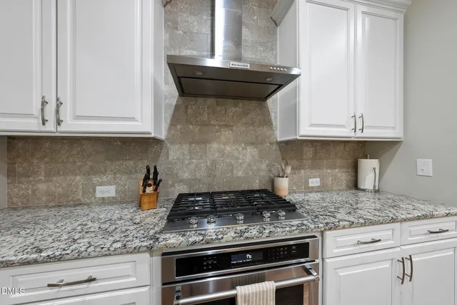 a large kitchen with stainless steel appliances granite countertop a stove refrigerator and a sink