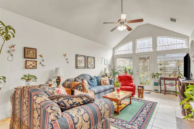 a living room with furniture a flat screen tv and a large window