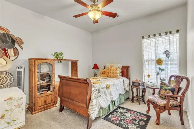a spacious bedroom with a bed a chandelier and large window