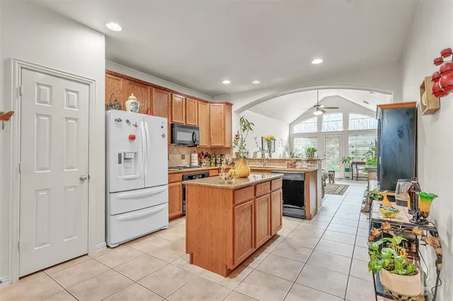 a kitchen with stainless steel appliances kitchen island granite countertop a refrigerator and a stove