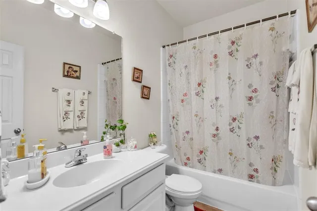 a bathroom with a sink a toilet and a large mirror