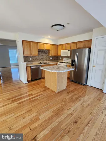 a view of kitchen with stainless steel appliances granite countertop a stove and refrigerator