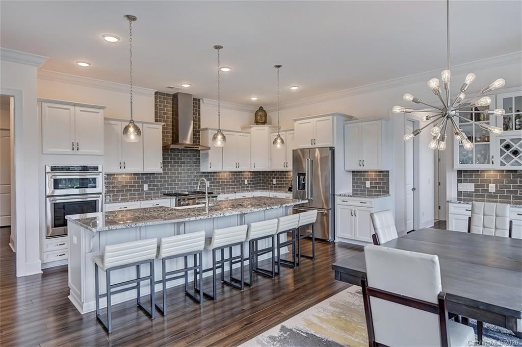 2227 Watermark Point Place Fort Mill, SC 29708 - Photo 15 of 43 a large kitchen with kitchen island a dining table and chairs