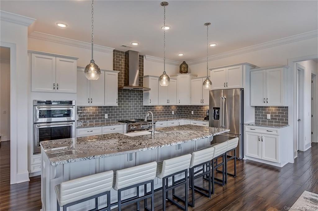 2227 Watermark Point Place Fort Mill, SC 29708 - Photo 16 of 43 a kitchen with stainless steel appliances granite countertop a kitchen island hardwood floor and a sink