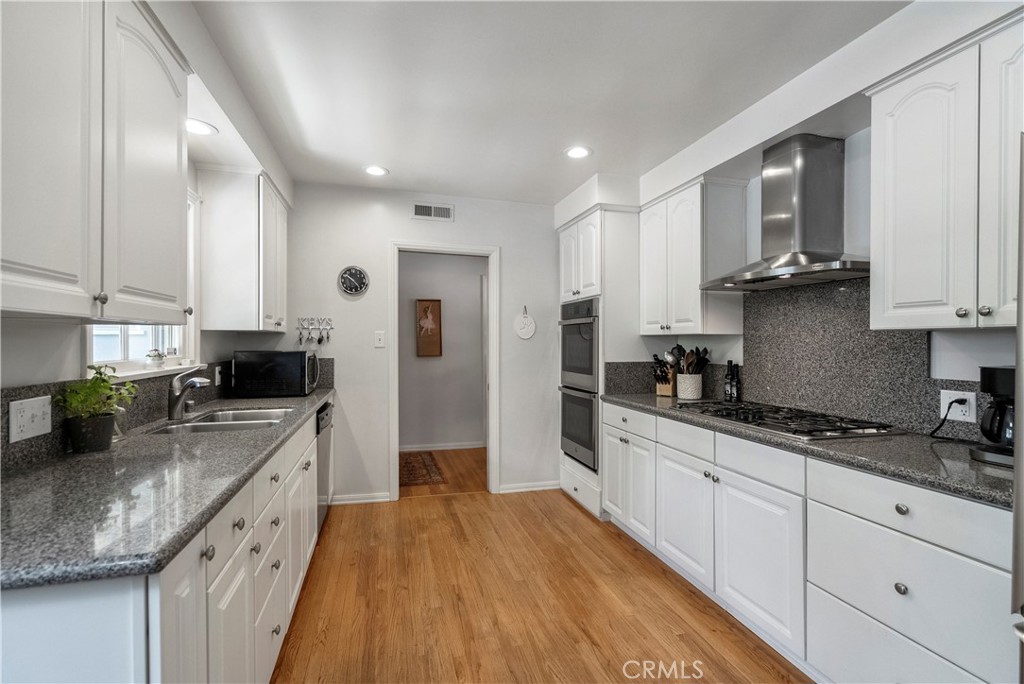 5407 Telefair Way Riverside, CA 92506 - Photo 10 of 35 a large kitchen with stainless steel appliances granite countertop a stove a sink a refrigerator and white cabinets