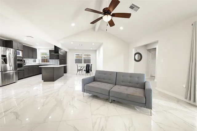 a living room with furniture and kitchen view