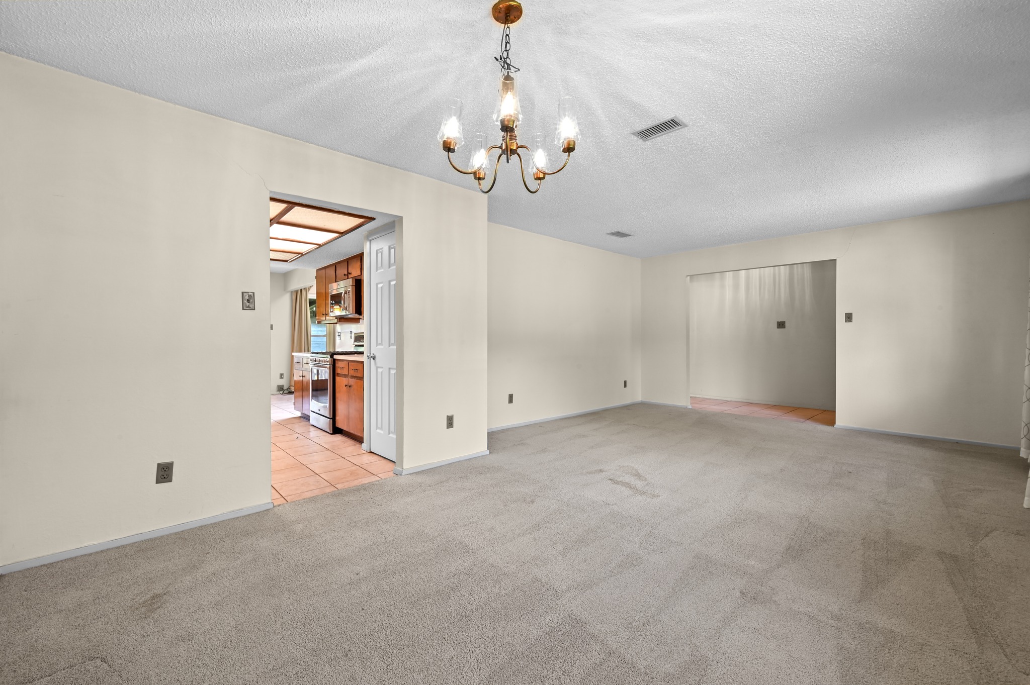10504 Hard Rock Road Austin, TX 78750 - Photo 6 of 28 A classic chandelier illuminates the generously proportioned living area, flowing into the kitchen.