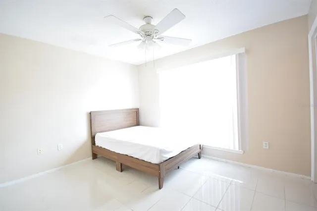 a room with a bed and a ceiling fan