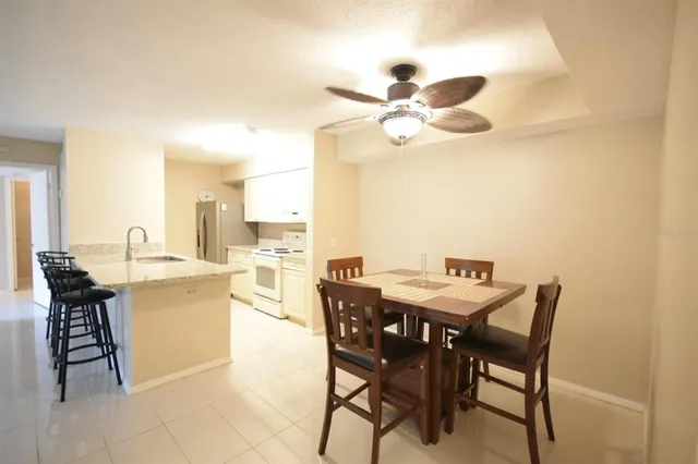 a view of a dining room with furniture and a chandelier fan