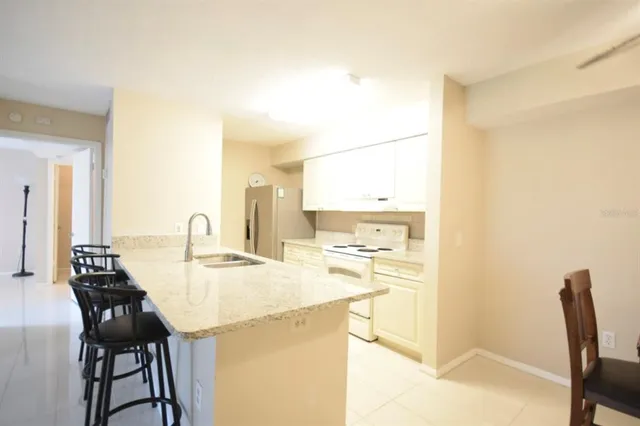 a kitchen with kitchen island a sink a stove and a refrigerator