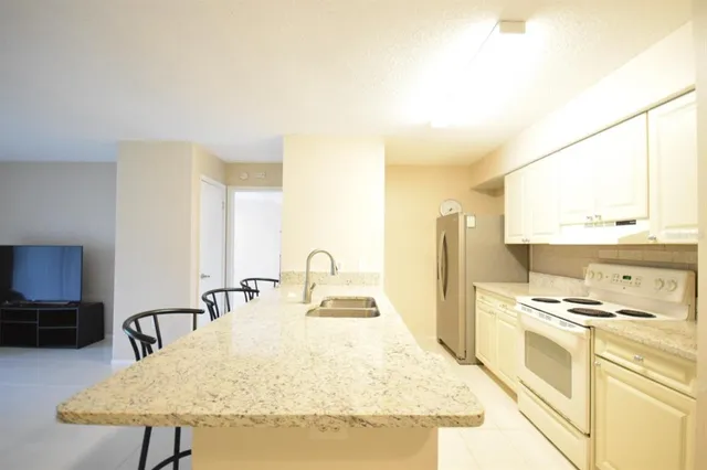 a kitchen with a stove a sink and a refrigerator