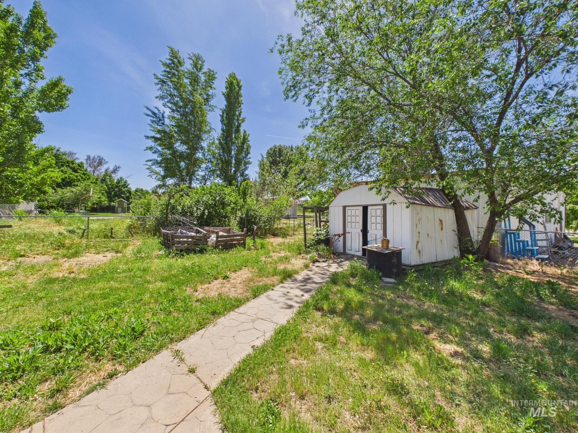 1527 North Plaza Road Emmett, ID 83617 - Photo 30 of 33 White-painted outbuilding with double doors, bordered by a concrete-paver pathway
