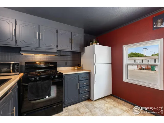 a kitchen with granite countertop a refrigerator stove and cabinets