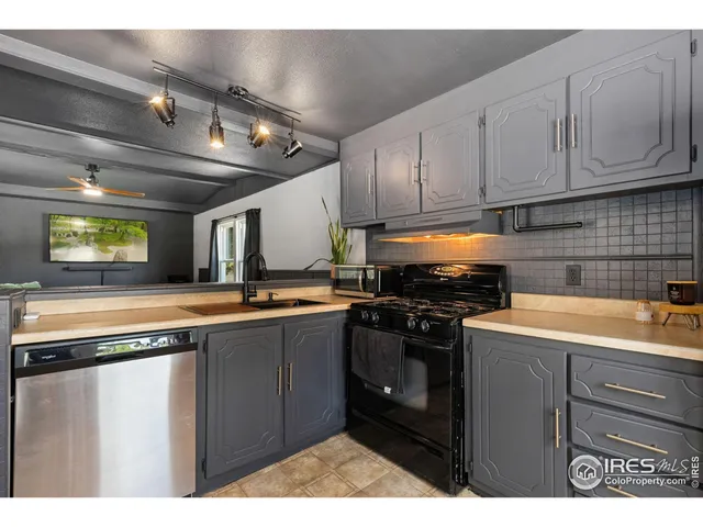 a kitchen with stainless steel appliances granite countertop a sink a stove and cabinets