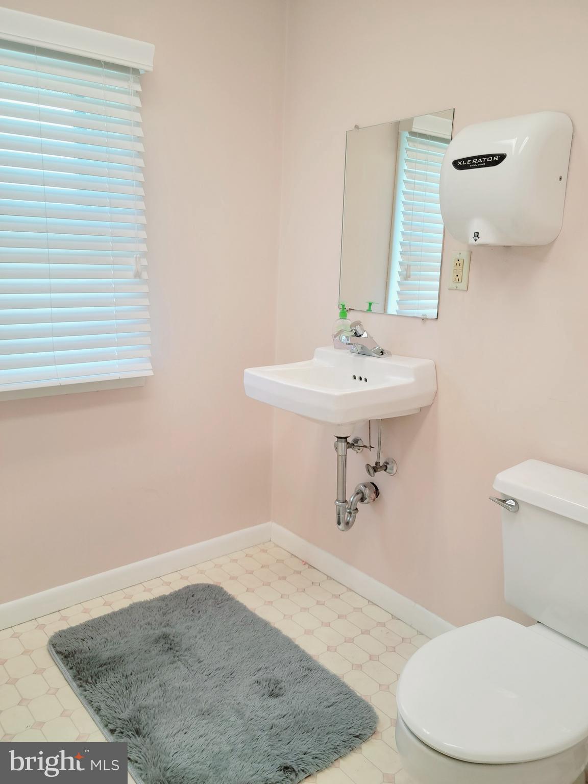 902 Laurel Road Lindenwold, NJ 08021 - Photo 13 of 22 a bathroom with a sink a toilet and mirror