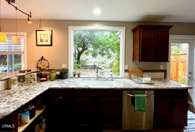 a kitchen with granite countertop a sink window and cabinets