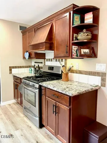 a kitchen with stainless steel appliances granite countertop a stove a sink and a microwave