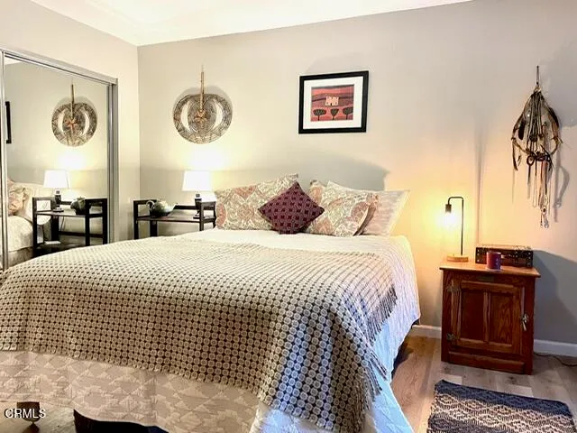 a bedroom with a bed and a lamp on dresser