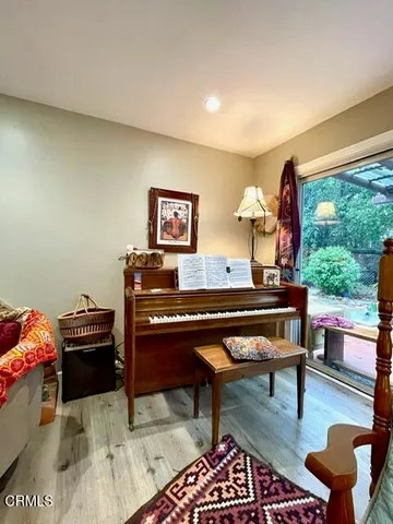 a living room with furniture and a piano