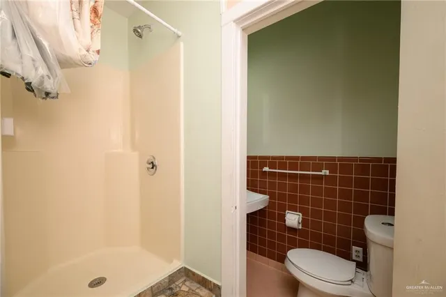 a bathroom with a toilet and a shower