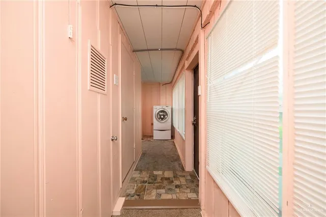 a view of a hallway with wooden floor and a window