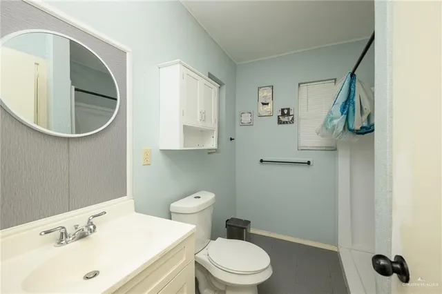 a bathroom with a sink a toilet and a mirror