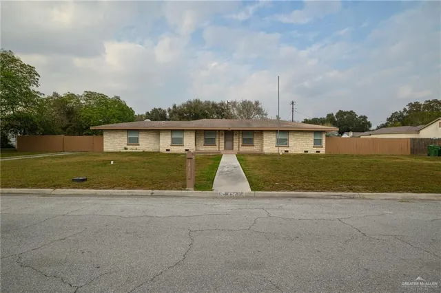 a view of a house next to a yard with big trees