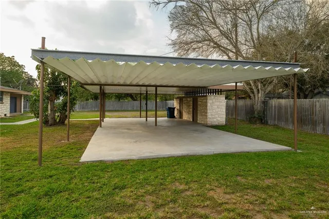 a view of a patio with table and chairs under an umbrella