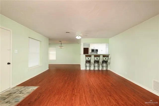 a furnished livingroom with entryway and wooden floor