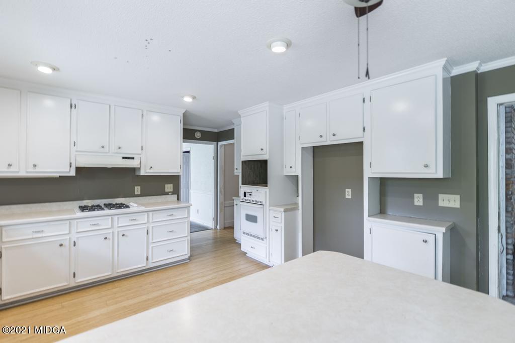 225 Beacon Hill Road Macon, GA 31210 - Photo 12 of 29 a kitchen with white cabinets and stainless steel appliances